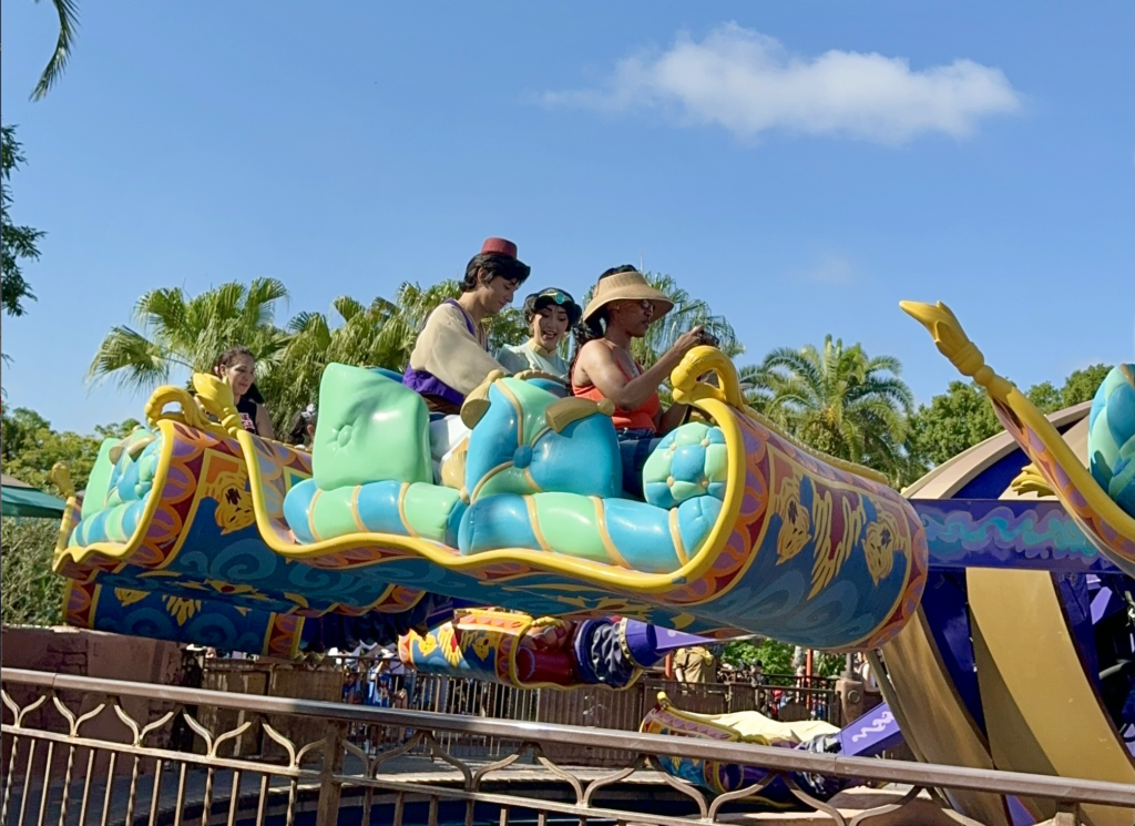 Guests riding The Magic Carpets of Aladdin in Disney World with Aladdin and Jasmin themselves!